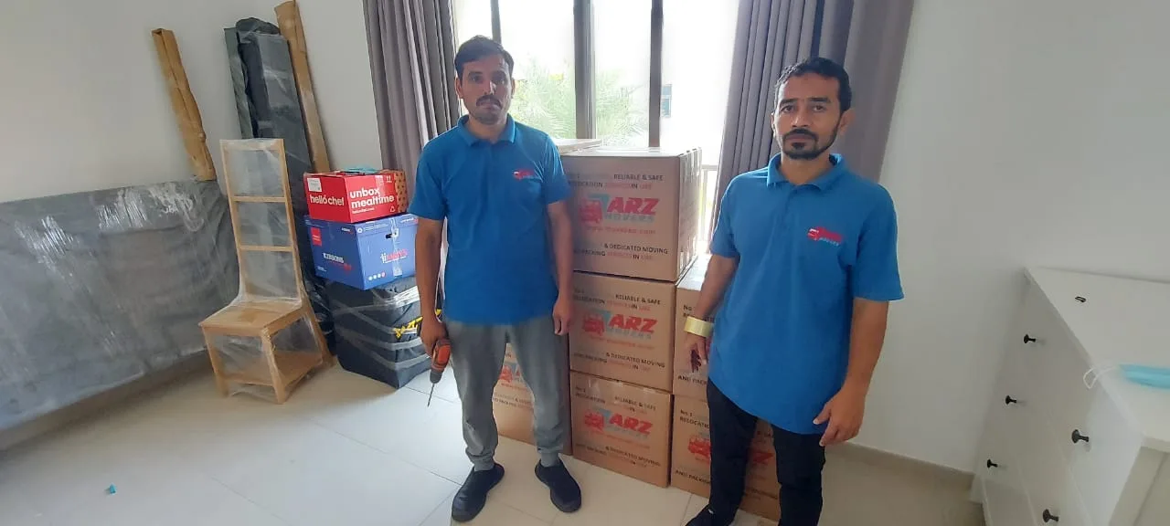 ARZ Movers crew with labelled moving boxes at a Dubai property