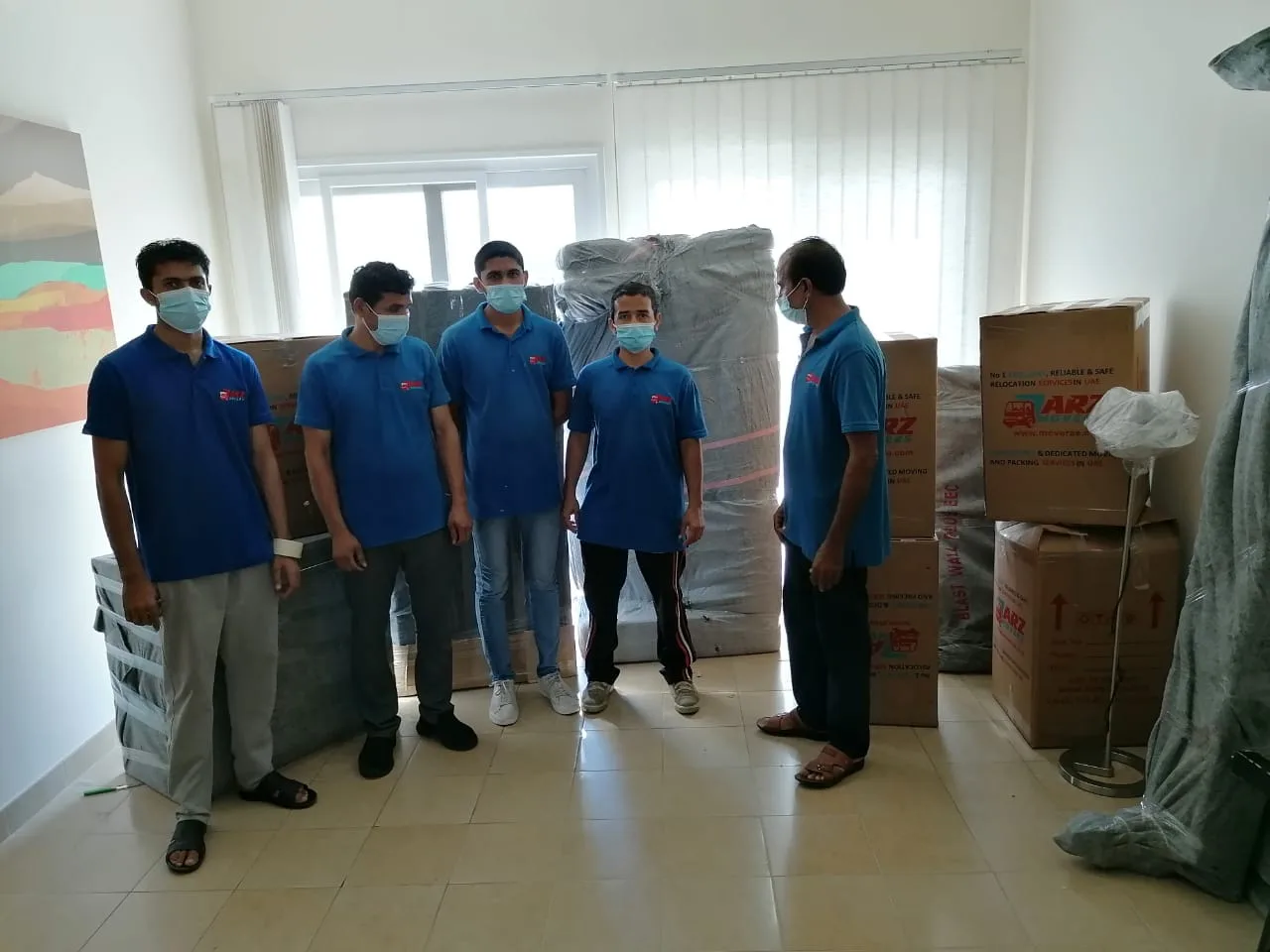 ARZ Movers team with wrapped furniture during a Dubai apartment move