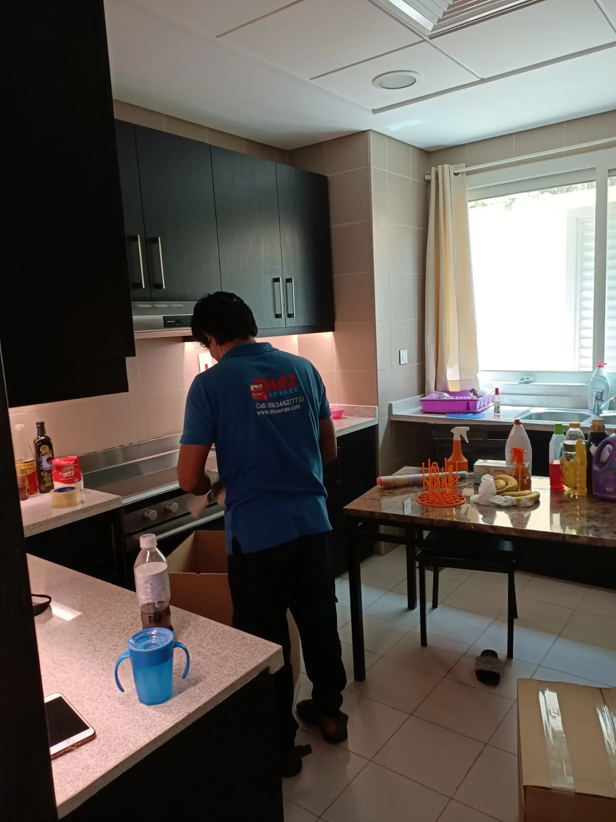 ARZ Movers packer boxing kitchen contents in a Dubai apartment